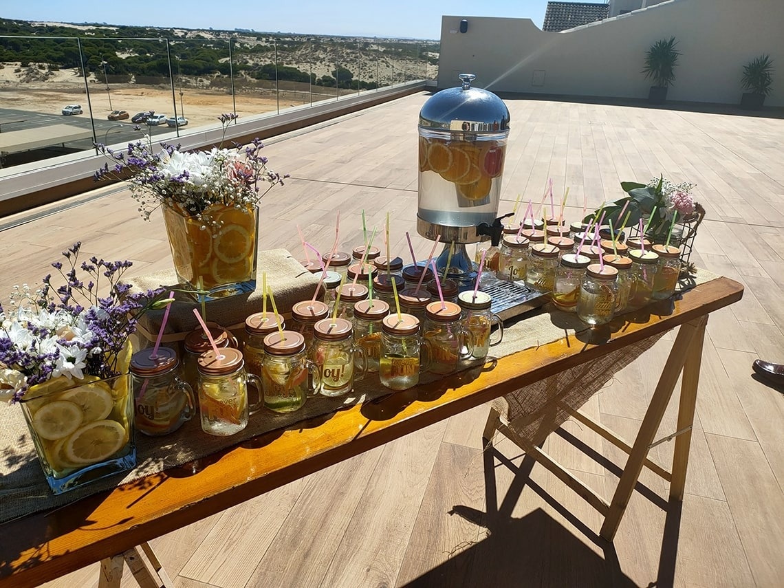 una mesa de madera llena de frascos de vidrio con pajitas y limones