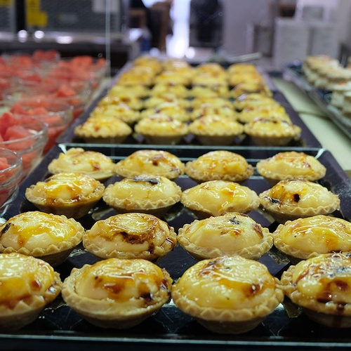 un montón de pasteles y tazones de sandía en una mesa