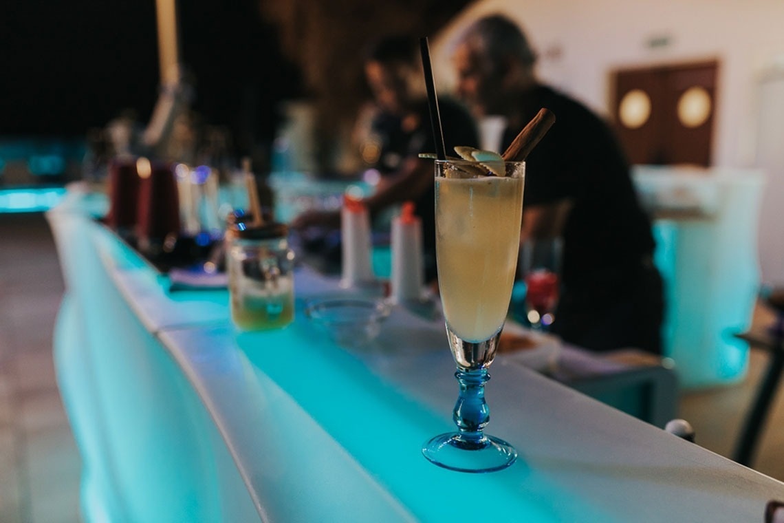 um copo de champanhe com uma palha em um bar