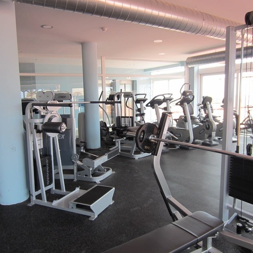 un gimnasio lleno de muchos aparatos y una barra