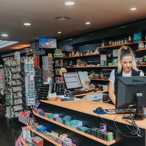 una mujer se sienta en un mostrador frente a una computadora dell