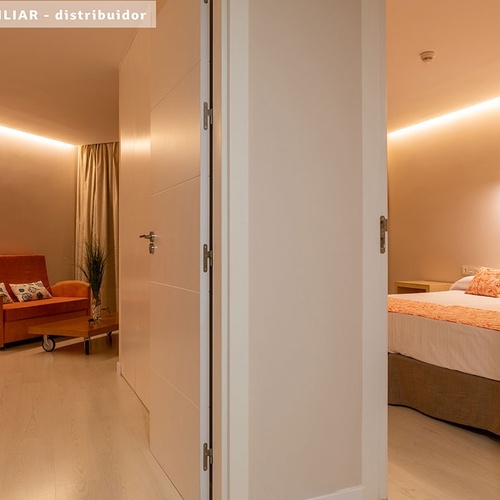 una puerta que conduce a una habitación con una cama y una silla
