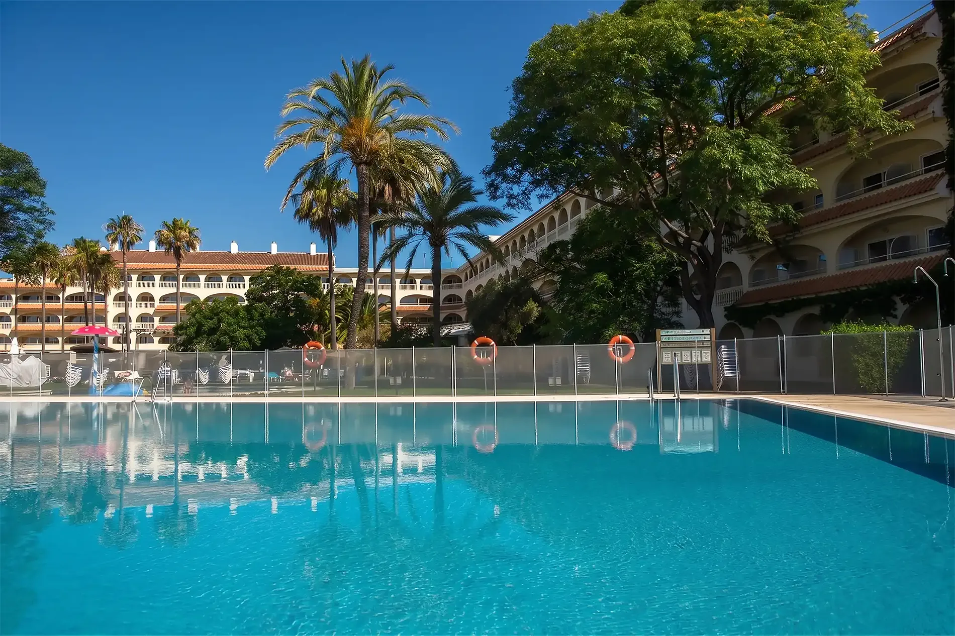 Piscina cristalina y palmeras en hotel de lujo <p>	Gran Hotel del Coto</p>.