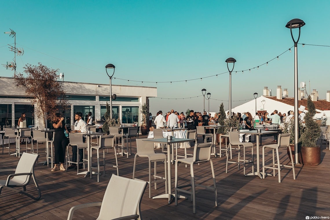 um grupo de pessoas está sentado em mesas ao ar livre