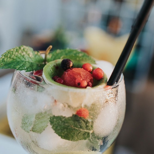 un primer plano de un cóctel con hielo y frutas