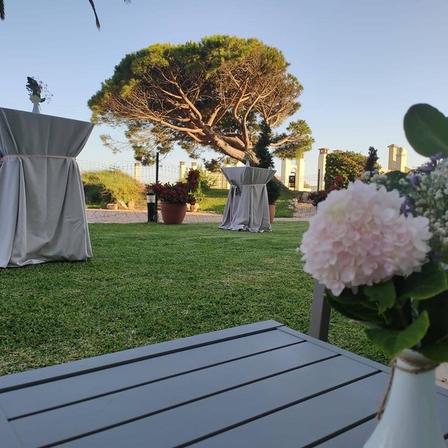 un jarrón de flores se sienta en una mesa al aire libre