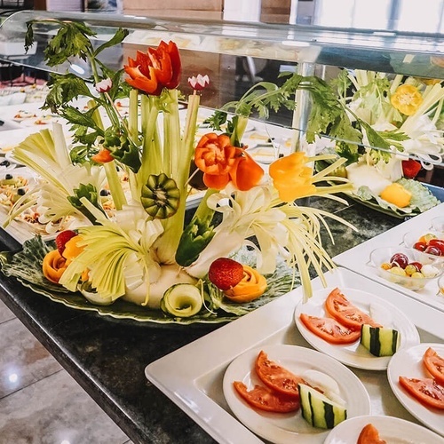 un buffet de comida con platos de tomates y pepinos