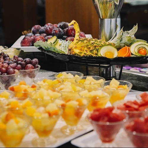 un buffet lleno de frutas y verduras en vasos