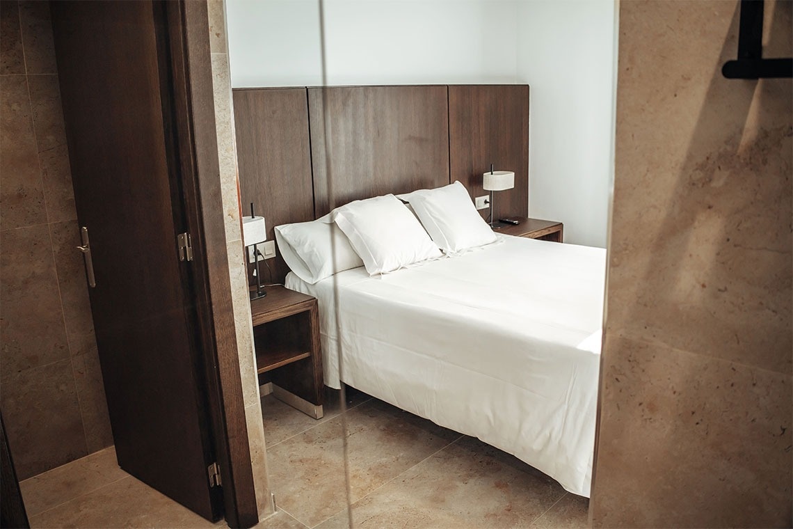 una habitación con una cama y una puerta de vidrio