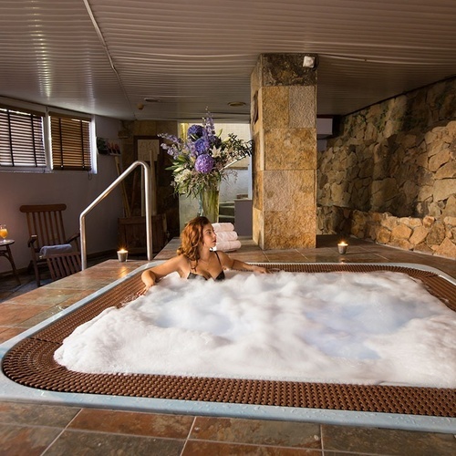 una mujer se sienta en un jacuzzi lleno de espuma