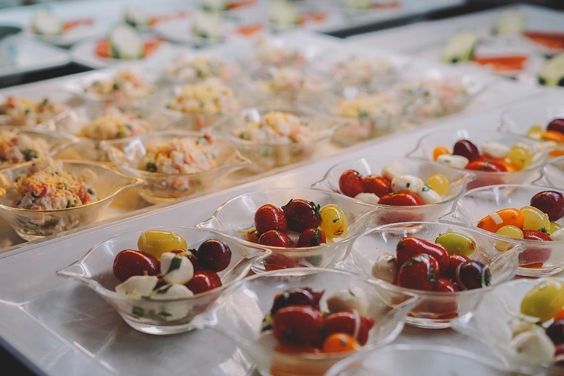 a buffet table with a variety of appetizers including tomatoes and mozzarella