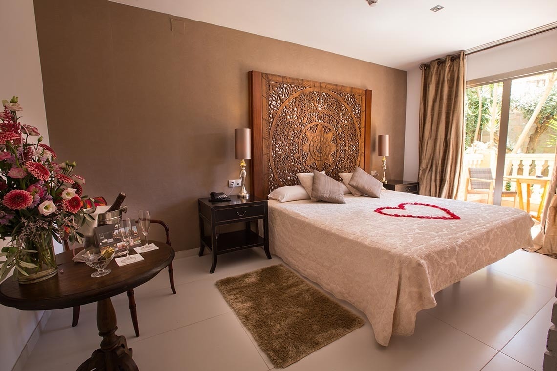 una habitación con una cama y una mesa con copas de vino