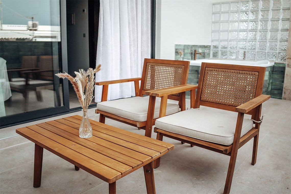 dos sillas de madera y una mesa de madera en un balcón