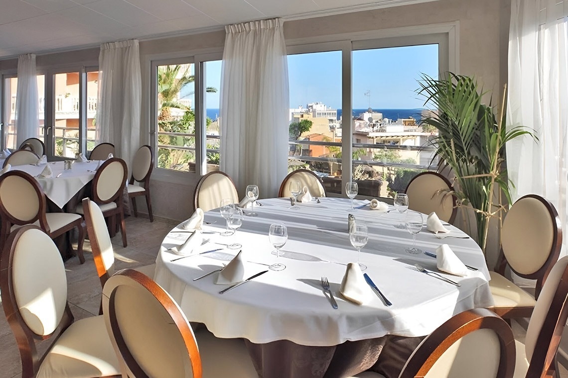 a restaurant with tables and chairs and a view of the ocean