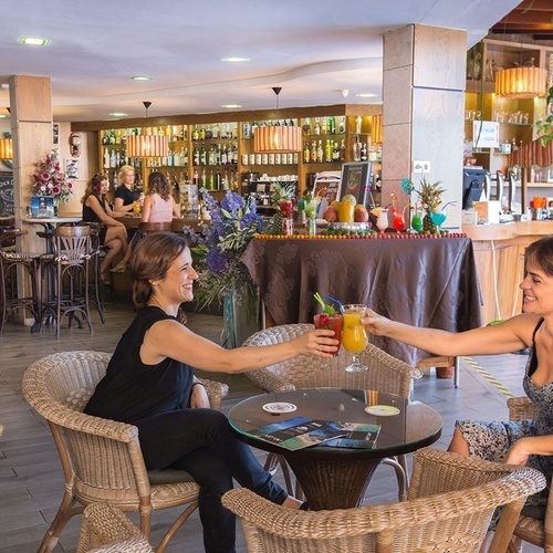 dos mujeres brindan con cócteles en un restaurante