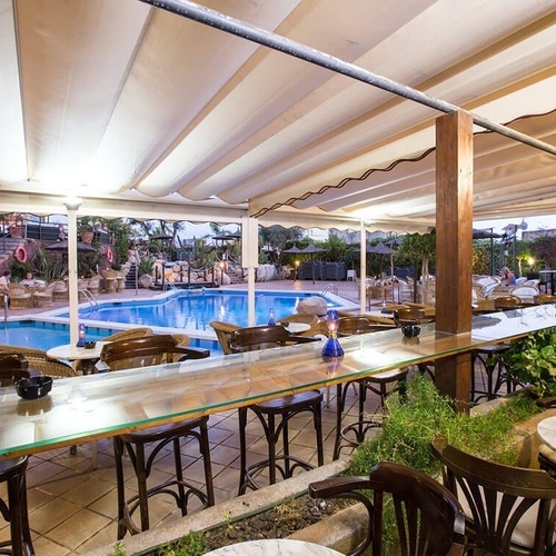 una piscina rodeada de mesas y sillas en un restaurante