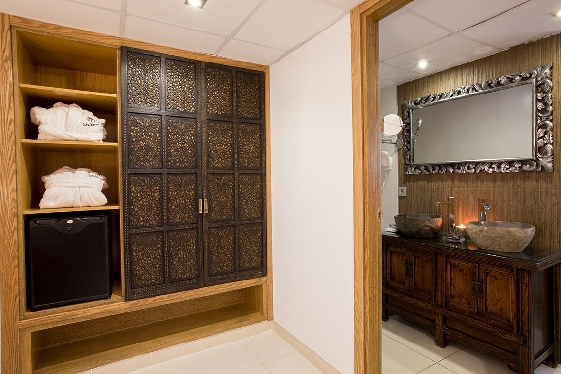 una puerta que conduce a un baño con dos lavabos y un espejo