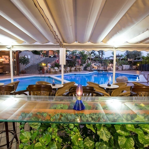 una piscina rodeada de mesas y sillas en un restaurante