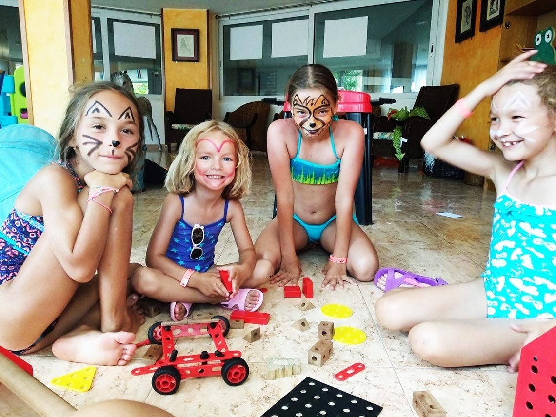 a group of young girls sitting on the floor with their faces painted
