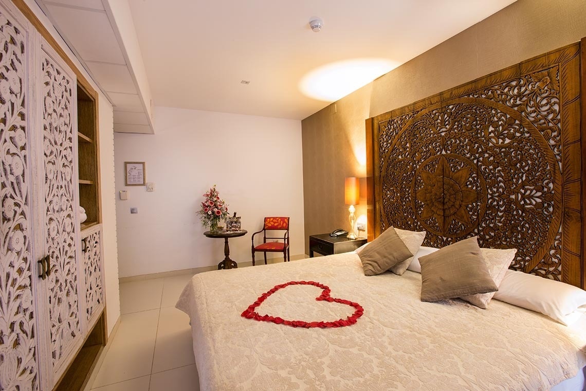 Una cama con un corazón hecho de pétalos