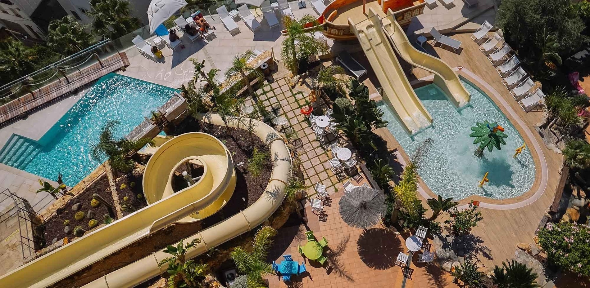 an aerial view of a large swimming pool surrounded by chairs and tables