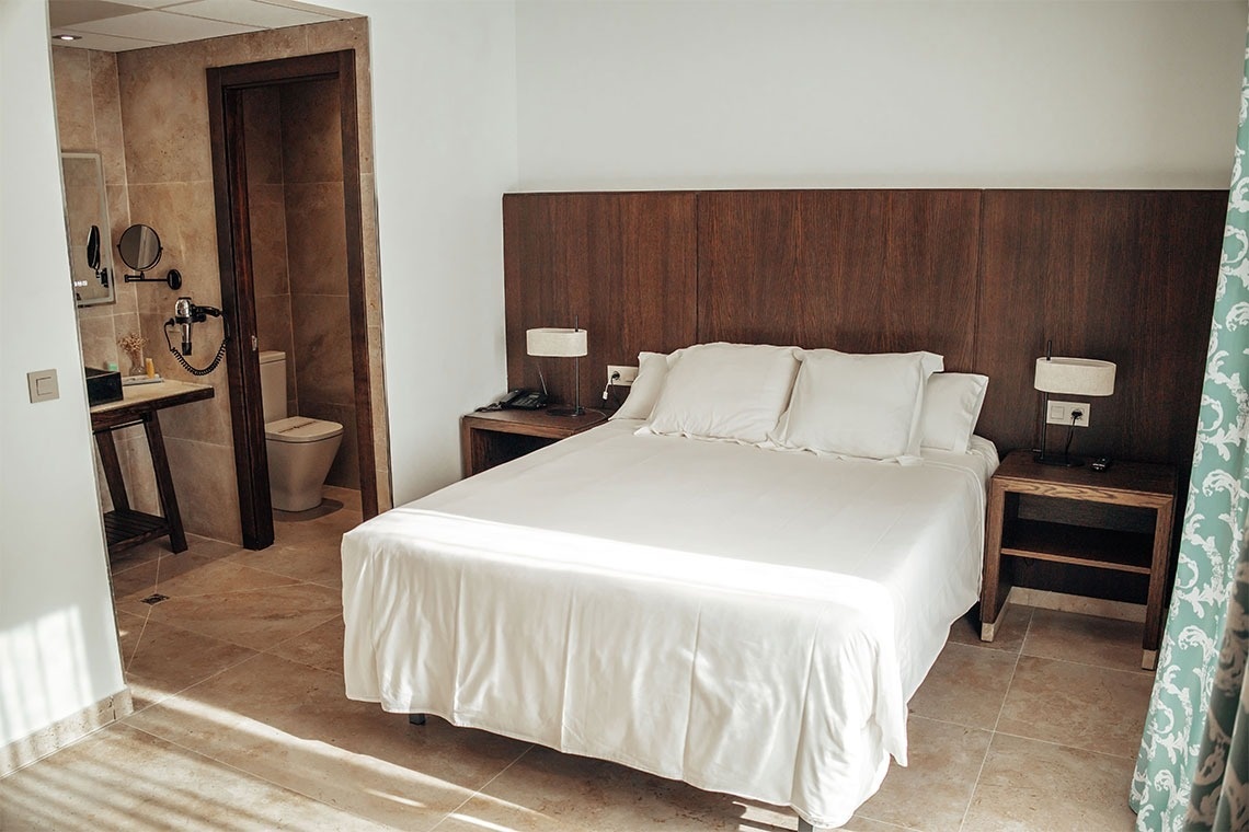 una habitación de hotel con una cama y dos mesitas de noche