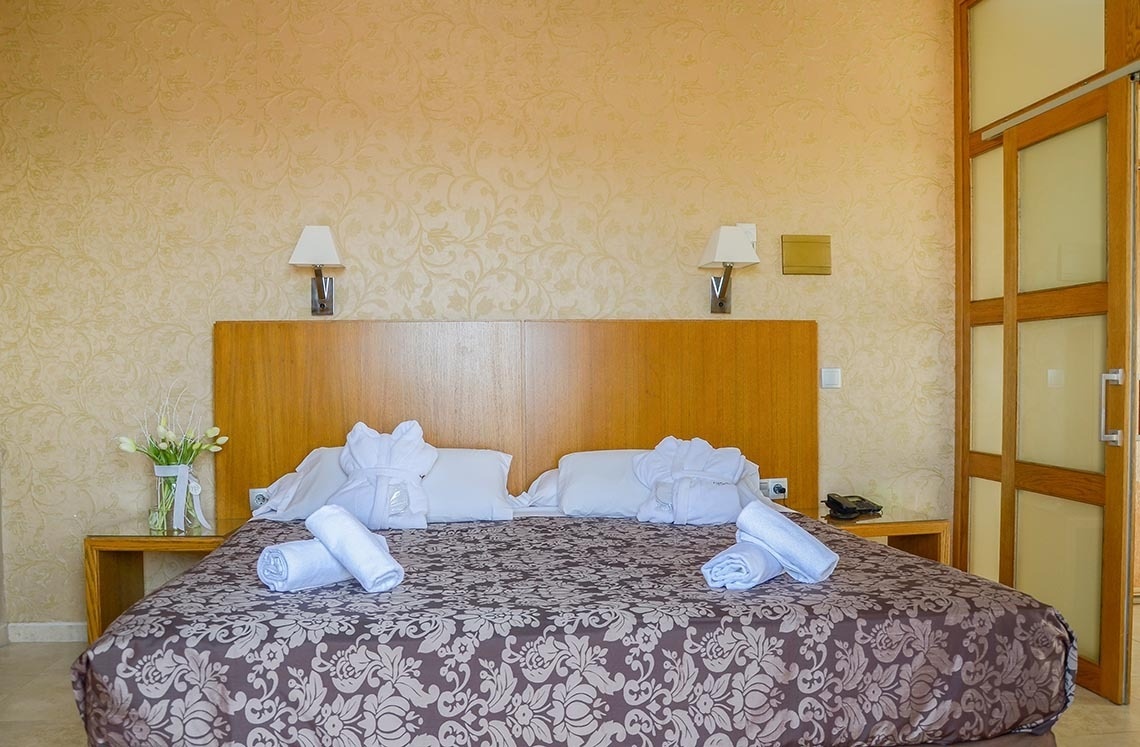 una habitación de hotel con una cama y dos mesitas de noche