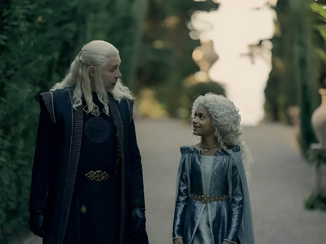 мужчина с белыми волосами стоит рядом с девушкой в голубом платье