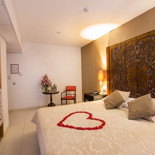 una cama con un corazón hecho de rosas encima