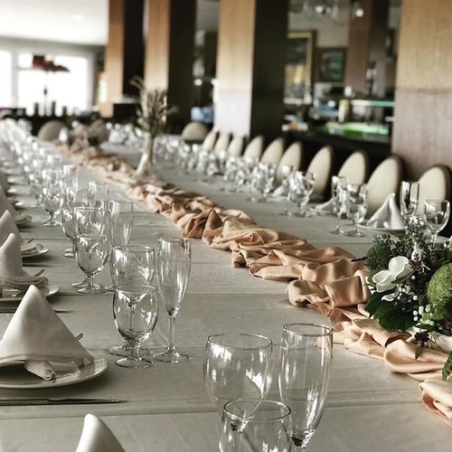 una mesa larga cubierta con platos y copas de vino