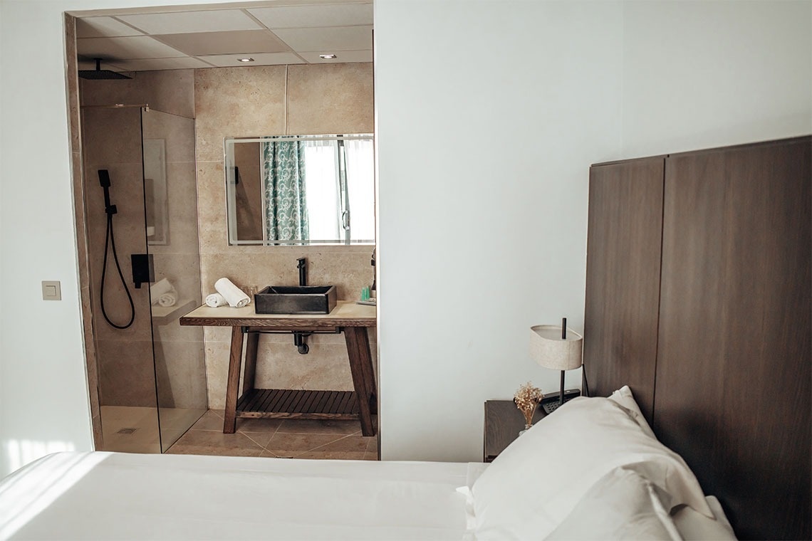 una habitación con una cama y un lavabo en el baño