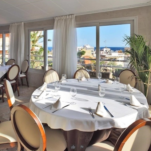 una mesa y sillas en un restaurante con una vista al océano