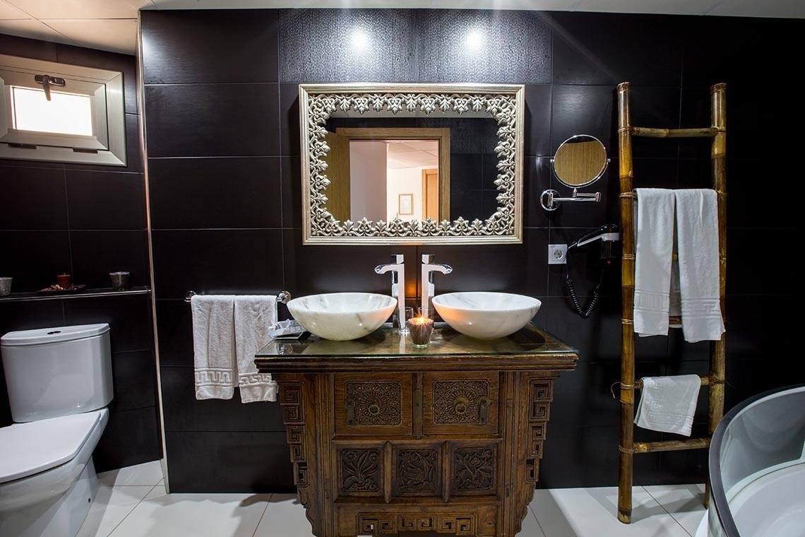 Un baño con 2 lavabos un inodoro y un espejo