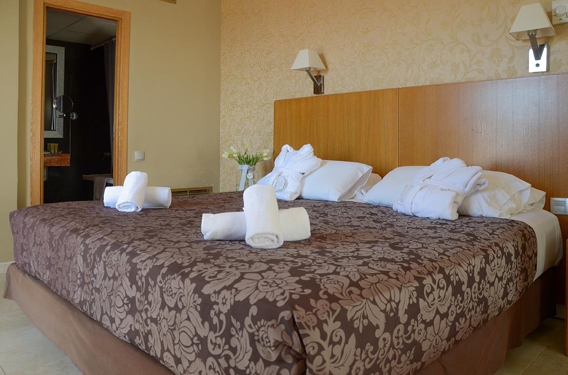 una cama en una habitación de hotel con toallas encima