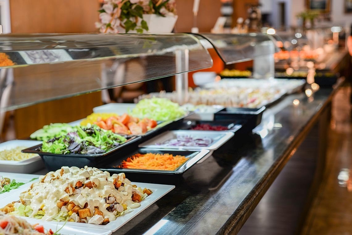 a buffet filled with lots of salads and vegetables