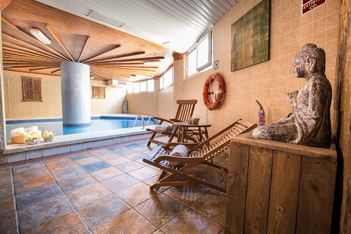 une piscine intérieure avec des chaises et une statue de bouddha
