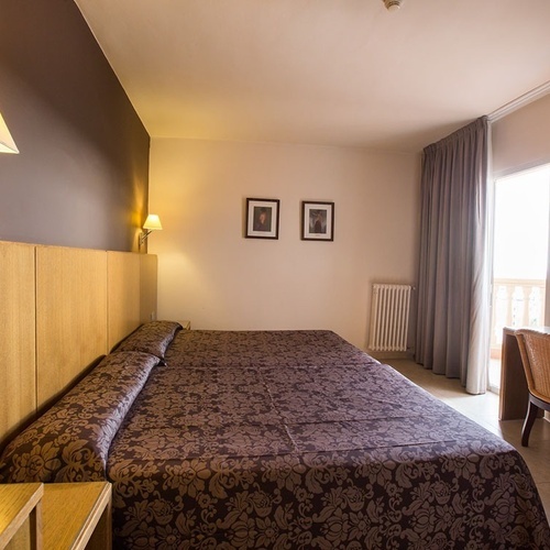 una habitación de hotel con una cama y una televisión