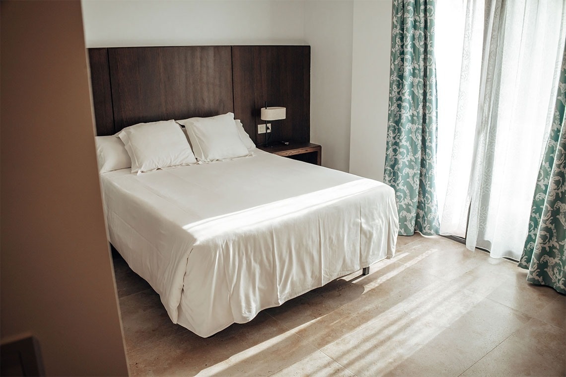 una habitación con una cama y una ventana con cortinas azules