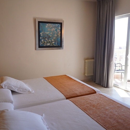 una habitación con dos camas y una pintura en la pared