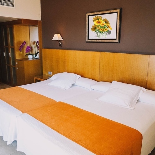 una habitación de hotel con dos camas y una pintura de girasoles en la pared