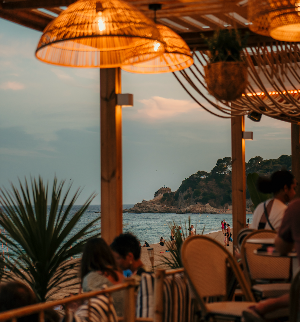 Ein Golfball balanciert am Rand eines Golflochs, während im unscharfen Hintergrund eine Golferin mit einem Golfschläger zu sehen ist.