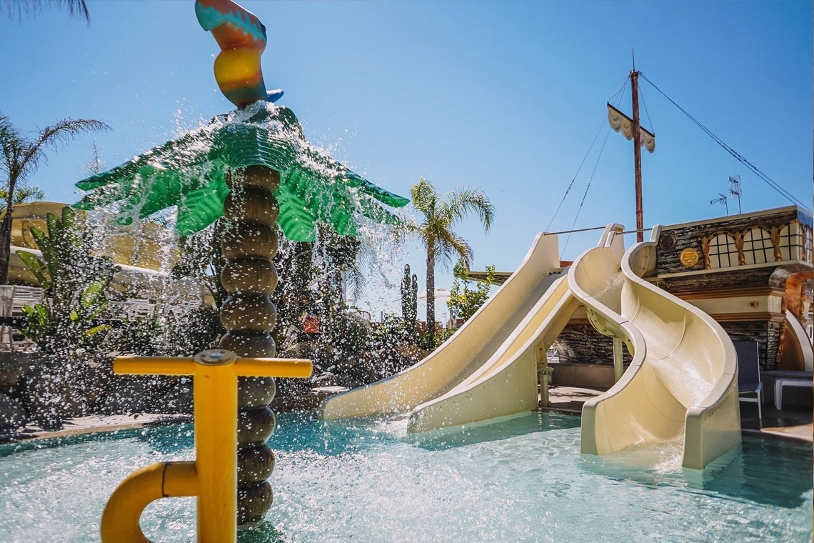 una piscina amb un edifici al fons