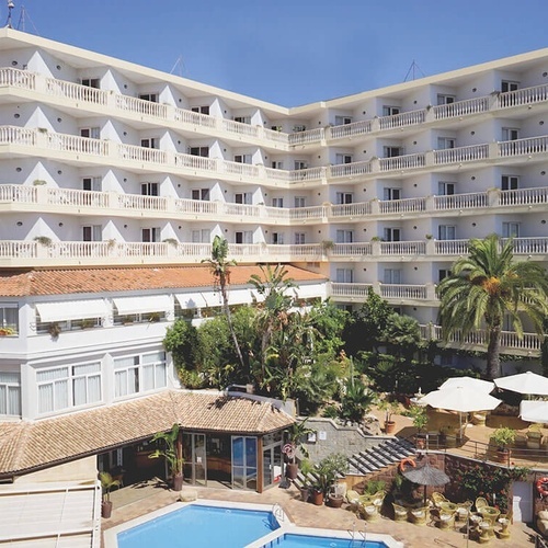 un gran edificio blanco con balcones y una piscina