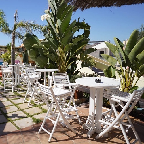 una fila de mesas y sillas blancas en un patio