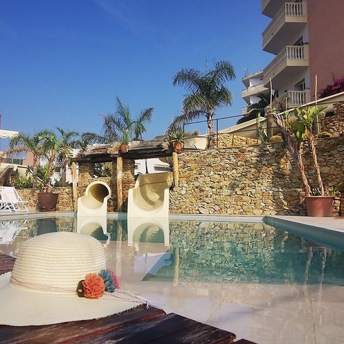 un sombrero está sentado en una mesa junto a una piscina
