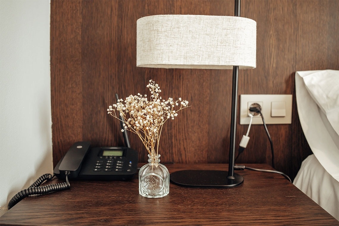 una mesa de madera con un teléfono y una lámpara