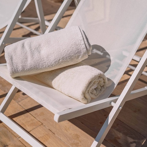 dos toallas blancas están apiladas en una silla blanca