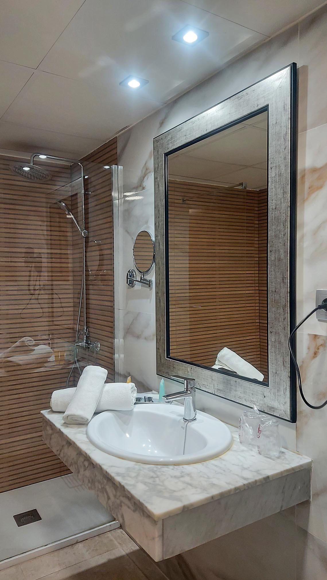 un baño con lavabo , espejo y ducha