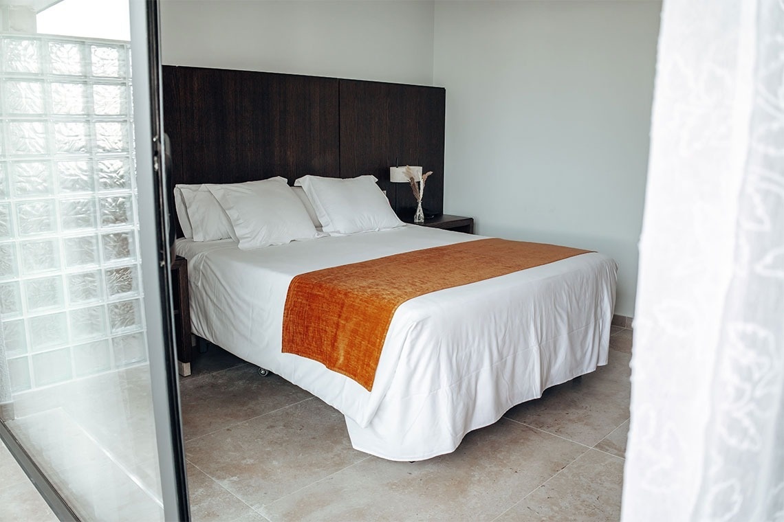 una habitación con una cama y una puerta de vidrio