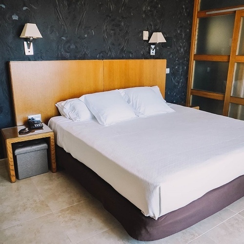 una habitación de hotel con una cama y un teléfono